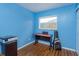 Bedroom features blue walls, a dark wood desk and sleek wood laminate flooring at 1219 Helen St, Apopka, FL 32703