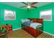 Bedroom features bright green walls, a ceiling fan, and a dark wood bed frame with storage at 1219 Helen St, Apopka, FL 32703