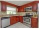 This kitchen features granite countertops, stainless steel appliances and dark wood cabinets at 1219 Helen St, Apopka, FL 32703