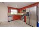 Functional kitchen with stainless steel appliances, granite countertops, and cherry wood cabinets at 1219 Helen St, Apopka, FL 32703