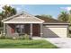Charming single-story home with a two-car garage and well-manicured front lawn at 1266 Limbali St, Mount Dora, FL 32757