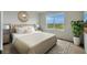 Serene main bedroom with large window, plush bedding and a decorative headboard at 1266 Limbali St, Mount Dora, FL 32757
