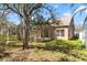 Exterior view of home's backyard featuring a lawn, screened in porch, and mature trees at 14720 Sweet Acacia Dr, Orlando, FL 32828