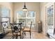 Bright breakfast nook with tile flooring, a glass-top table, and views of the backyard from the windows at 14720 Sweet Acacia Dr, Orlando, FL 32828