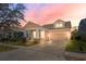 Charming single-Gathering home featuring a well-manicured lawn and a convenient two-car garage at sunset at 14720 Sweet Acacia Dr, Orlando, FL 32828