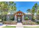Exterior view of the community clubhouse, featuring a peaked roof, stone columns, and decorative landscaping at 1558 Terra Verde Way, Ocoee, FL 34761