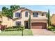 Charming two-story home featuring manicured landscaping, a brick driveway, and a two-car garage at 1558 Terra Verde Way, Ocoee, FL 34761
