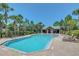 Community pool with chairs and cabana surrounded by manicured landscaping at 1558 Terra Verde Way, Ocoee, FL 34761