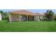 Exterior view of the home with a tile roof, a covered patio, and a spacious green lawn at 15698 Marina Bay Dr, Winter Garden, FL 34787