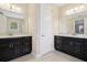 Dual vanity bathroom with dark cabinets and stylish mirrors, a functional space designed for morning routines at 15698 Marina Bay Dr, Winter Garden, FL 34787