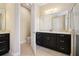 Bathroom featuring a dark vanity with double sinks and a toilet behind an open door at 15698 Marina Bay Dr, Winter Garden, FL 34787