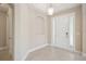 Bright foyer with a white front door, neutral tile flooring, and an alcove niche for decor at 15698 Marina Bay Dr, Winter Garden, FL 34787