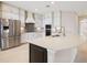 This kitchen boasts stainless steel appliances, white cabinets, a breakfast bar, and pendant lighting at 15698 Marina Bay Dr, Winter Garden, FL 34787
