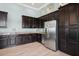Kitchenette features dark wood cabinets, granite countertops, stainless steel appliances, and tile flooring at 15698 Marina Bay Dr, Winter Garden, FL 34787