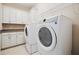 Well-equipped laundry room featuring modern washer and dryer and ample cabinet space at 15698 Marina Bay Dr, Winter Garden, FL 34787