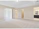 Large main bedroom with neutral tones, tray ceiling, and transitions to a private bathroom and walk-in closet at 15698 Marina Bay Dr, Winter Garden, FL 34787