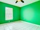 A bedroom with vibrant green walls, tile floors, and a bright window at 1606 Bismarck Dr, Deltona, FL 32725