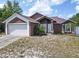 Charming single-Gathering home with a two-car garage and landscaping, ready for new owners at 1606 Bismarck Dr, Deltona, FL 32725