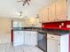 Open kitchen overlooking living area, with white cabinets and modern appliances at 1606 Bismarck Dr, Deltona, FL 32725