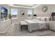 Stylishly furnished main bedroom features a tray ceiling, large windows, and modern decor at 16217 Prairie School Dr, Winter Garden, FL 34787