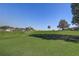 Expansive backyard view featuring a well-manicured green golf course and mature trees at 1900 Nw 57Th Ct, Ocala, FL 34482