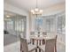 Bright dining area with a chandelier and sliding doors to a sunroom that let in plenty of natural light at 1900 Nw 57Th Ct, Ocala, FL 34482