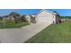 Single-story home with an attached garage, long driveway, and beautiful landscaping at 1900 Nw 57Th Ct, Ocala, FL 34482