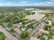 Scenic aerial view of a community near a lake, featuring a pool, lush greenery, and a tennis court at 200 Maitland Ave # 52, Altamonte Springs, FL 32701