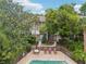 Exterior view of a two-story condo building surrounded by mature trees and a private outdoor patio with furniture at 200 Maitland Ave # 52, Altamonte Springs, FL 32701