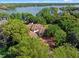 Sprawling lakefront home with a terracotta tile roof surrounded by mature trees at 2001 Bett Mar Ln, Winter Park, FL 32789