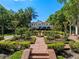Beautifully landscaped backyard with manicured gardens, brick pathways, and a view of the grand home at 2001 Bett Mar Ln, Winter Park, FL 32789