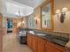 Spacious bathroom featuring dual sinks, a soaking tub, natural stone countertops, and elegant lighting at 2001 Bett Mar Ln, Winter Park, FL 32789