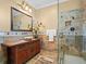 Bathroom featuring an intricate vanity, stone countertop, vessel sink, and a glass-enclosed shower at 2001 Bett Mar Ln, Winter Park, FL 32789