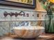 Close-up of a bathroom with a unique vessel sink, decorative backsplash and a vase of sunflowers at 2001 Bett Mar Ln, Winter Park, FL 32789