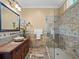 Bathroom featuring an intricate vanity, stone countertop, vessel sink, and a glass-enclosed shower at 2001 Bett Mar Ln, Winter Park, FL 32789
