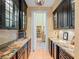 Butler's pantry featuring dark cabinets, granite countertops, and open doorway to dining room at 2001 Bett Mar Ln, Winter Park, FL 32789