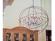 Ornate chandelier hangs above wooden cabinet in high ceiling dining room with natural light at 2001 Bett Mar Ln, Winter Park, FL 32789