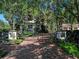 Elegant estate featuring a brick driveway, wrought iron gate, and mature trees surrounding the property at 2001 Bett Mar Ln, Winter Park, FL 32789
