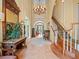 Grand foyer featuring a high ceiling, elegant chandelier, curved staircase, and decorative tile flooring at 2001 Bett Mar Ln, Winter Park, FL 32789