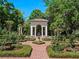 Beautiful landscaped garden with brick pathways, hedges, roses, and a charming garden structure at 2001 Bett Mar Ln, Winter Park, FL 32789