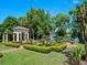 Lakefront property featuring a well-maintained formal garden with brick paths and manicured hedges at 2001 Bett Mar Ln, Winter Park, FL 32789