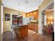Cozy kitchen featuring an island with seating and granite countertops, with wooden cabinets and tile floors at 2001 Bett Mar Ln, Winter Park, FL 32789