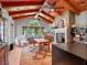 An airy living room featuring exposed wood beams, a stone fireplace, and large windows at 2001 Bett Mar Ln, Winter Park, FL 32789