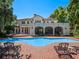 Expansive pool area with brick patio, lounge chairs, and elegant architecture, creating a luxurious backyard retreat at 2001 Bett Mar Ln, Winter Park, FL 32789