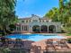 Back of home with pool, brick pavers, lounge chairs, and lush landscaping at 2001 Bett Mar Ln, Winter Park, FL 32789