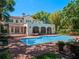 Inviting pool area with a well-maintained pool, brick patio, and lush greenery surrounding the elegant home at 2001 Bett Mar Ln, Winter Park, FL 32789
