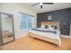 Well-lit bedroom with a dark accent wall, ceiling fan, and a minimalist decor at 204 E South St # 2061, Orlando, FL 32801