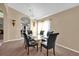 Dining room featuring a glass table, black chairs and modern light fixture at 213 Hideaway Beach Ln, Kissimmee, FL 34746