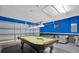 Game room features a pool table, comfortable seating, and adjacent garage access at 213 Hideaway Beach Ln, Kissimmee, FL 34746