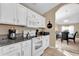 Open kitchen with white cabinets, granite countertops and seating at the dining table at 213 Hideaway Beach Ln, Kissimmee, FL 34746